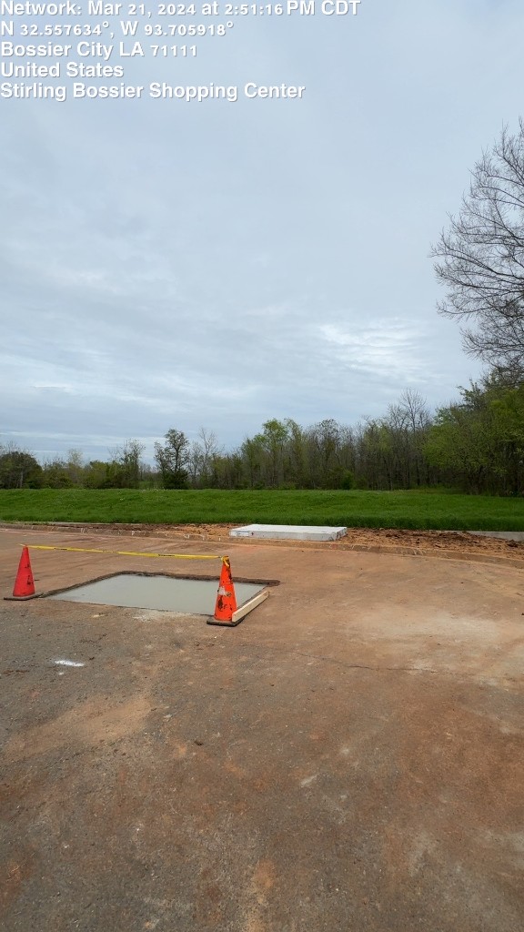 Fresh concrete pad curing at a commercial shopping center job site