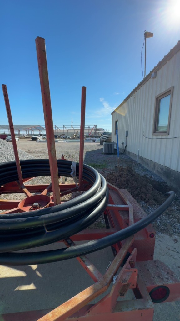 Large conduit coil on a dispenser trailer at a commercial building site