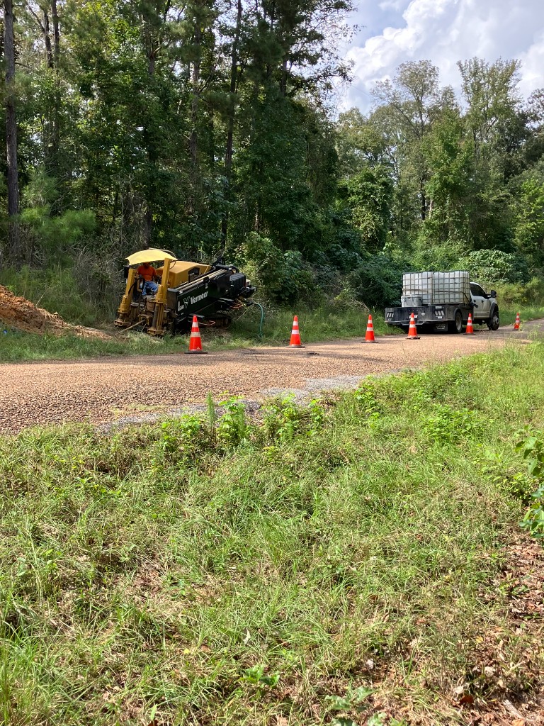 Vermeer drill rig staged on a roadside work zone with traffic cones